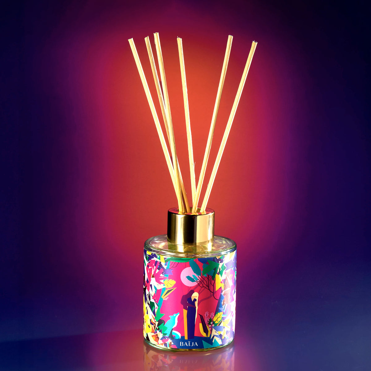 Bouquet parfumé Minuit Chéri avec ses tiges diffusantes, sur fond dégradé violet et orangé.