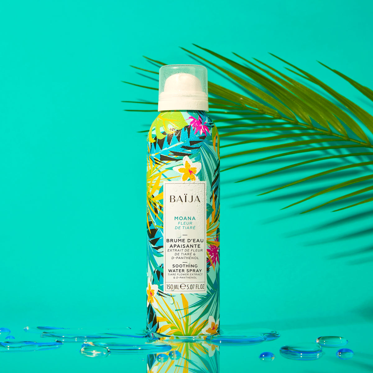 Brume d'eau apaisante Moana entourée d'une feuille de palmier, sur fond turquoise.