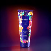 Tube de gel douche corps nourrissant Minuit Chéri à l’extrait de karité, sur fond dégradé violet et orangé.