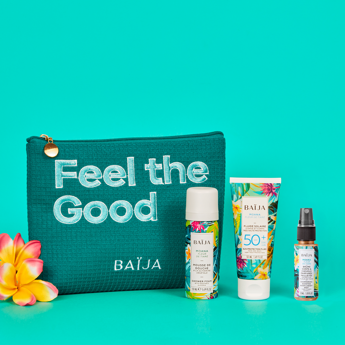 Coffret solaire Moana avec la trousse verte « Feel the Good », contenant une mousse de douche Moana 50ml, un fluide solaire SPF 50+ 50ml et une brume corps et cheveux parfumée pailletée 30ml, présentés sur fond turquoise.