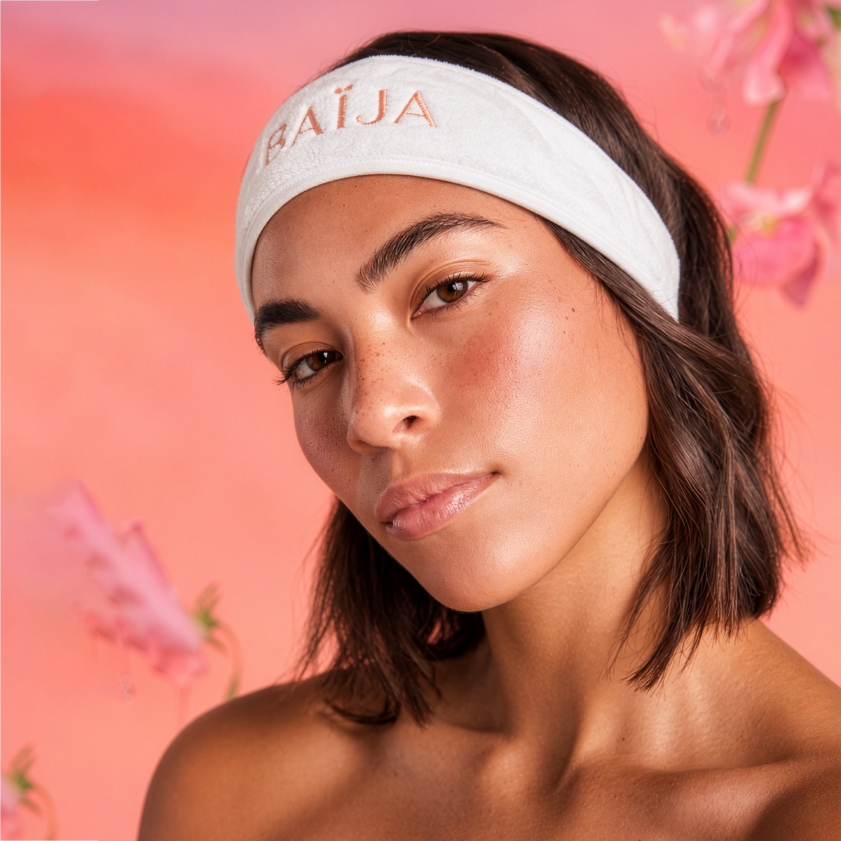 Femme portant un bandeau de soin blanc Baïja lors d’une routine beauté sur fond rose