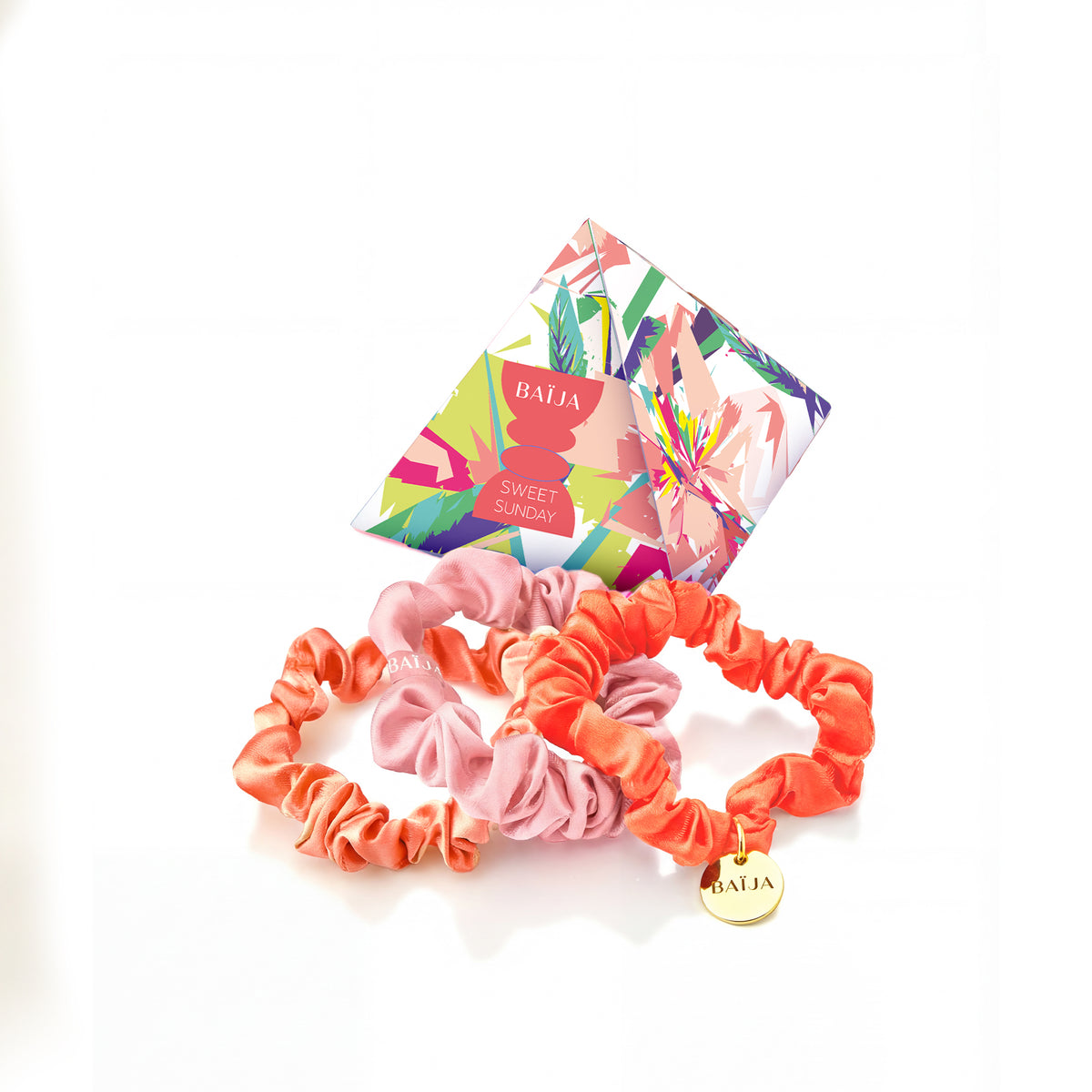 Set de chouchous satinés Baïja Sweet Sunday, coloris rose et corail, accompagné de sa pochette imprimée signature