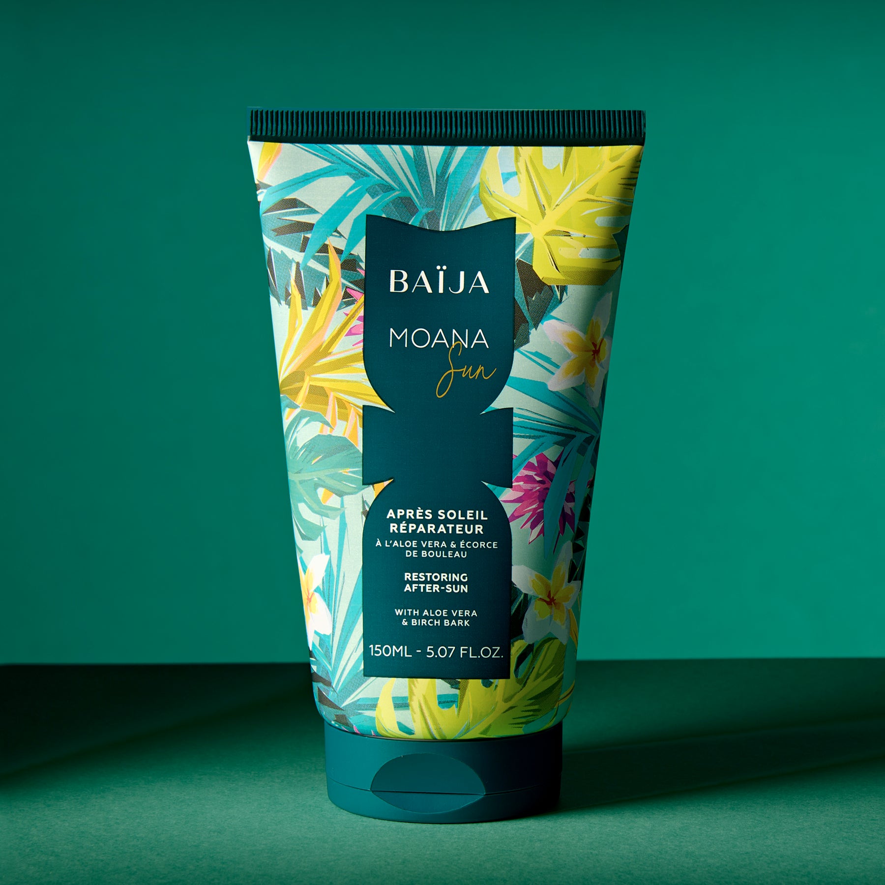 Tube “BAÏJA MOANA Sun – Après Soleil Réparateur” posé debout sur une surface assortie, devant un fond vert/vert-turquoise. Composition simple, produit seul au centre avec de l’espace négatif autour. Lumière directionnelle créant une ombre marquée et une ambiance studio.
