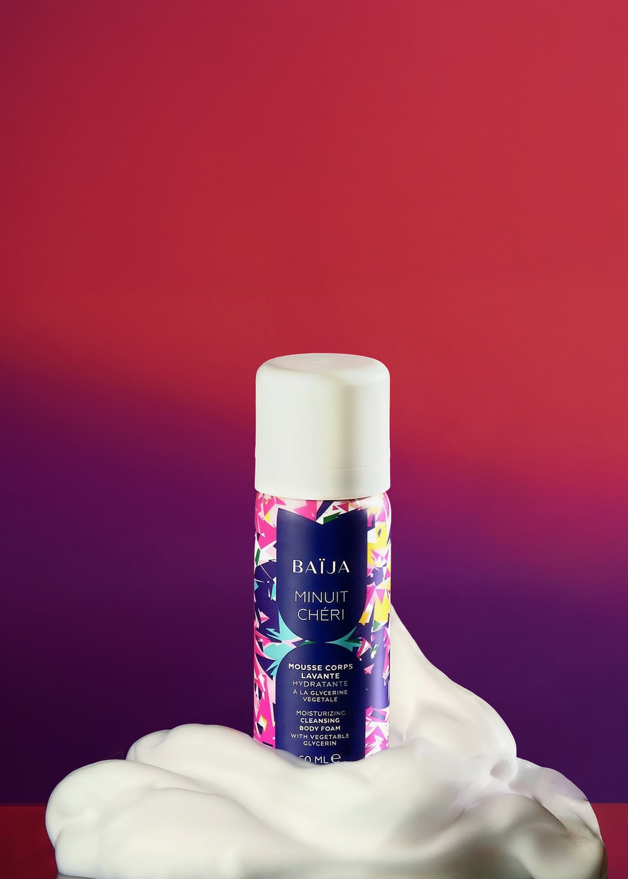 Flacon de mousse corps lavante hydratante BAÏJA Minuit Chéri, capot blanc, entouré d’une mousse généreuse, sur un fond rouge et violet en dégradé.