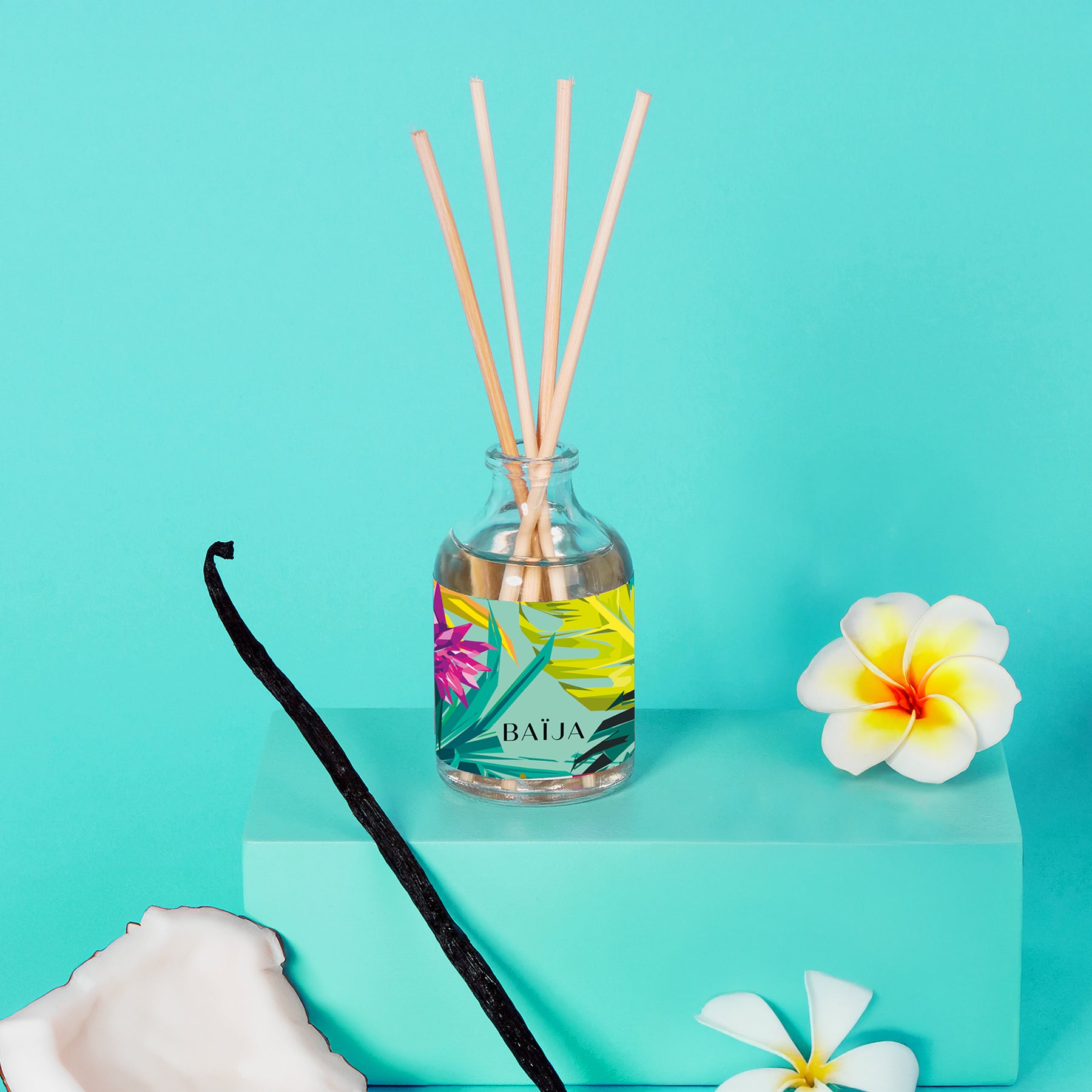 Bouquet parfumé BAÏJA Moana avec bâtonnets diffuseurs, entouré d’une gousse de vanille, d’un morceau de noix de coco et de fleurs de tiaré sur un fond turquoise lumineux.