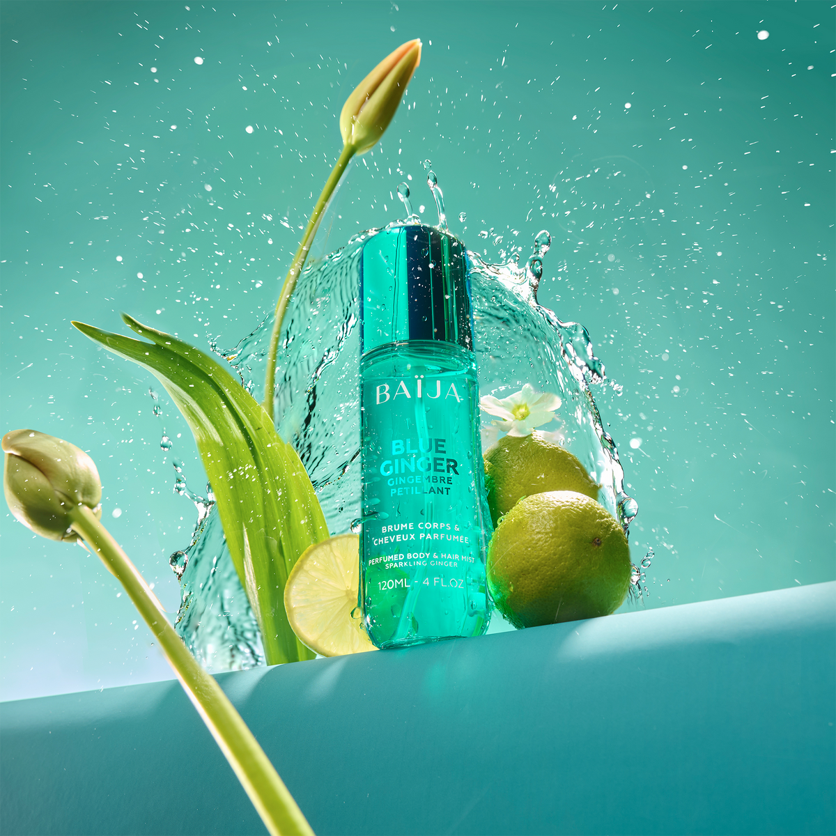 Flacon Baïja Blue Ginger entouré d’éclaboussures d’eau, feuilles vertes et citron vert coupé, ambiance fraîche sur fond lagon.