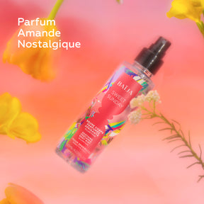 Brume corps parfumée apaisante Baïja Sweet Sunday aux notes d’amande, mise en scène dans une ambiance florale aux tons rosés.