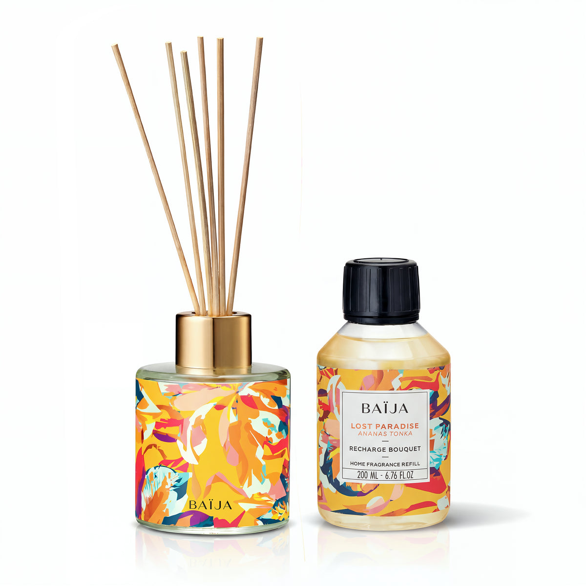 Diffuseur Baïja aux motifs chauds orangés avec tiges en rotin, accompagné de la recharge bouquet Lost Paradise ananas tonka 200 ml, fond blanc.