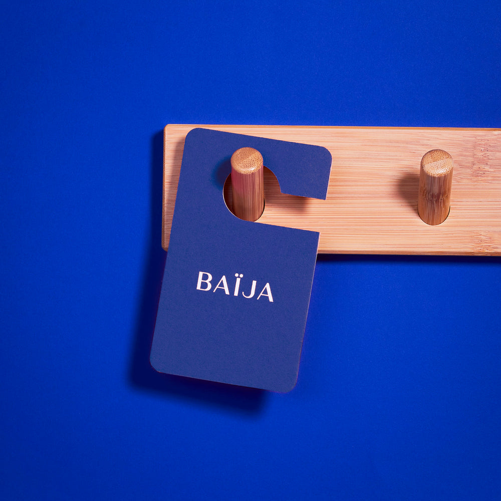 Parfum voiture Blue Ginger suspendu sur fond bleu électrique. 