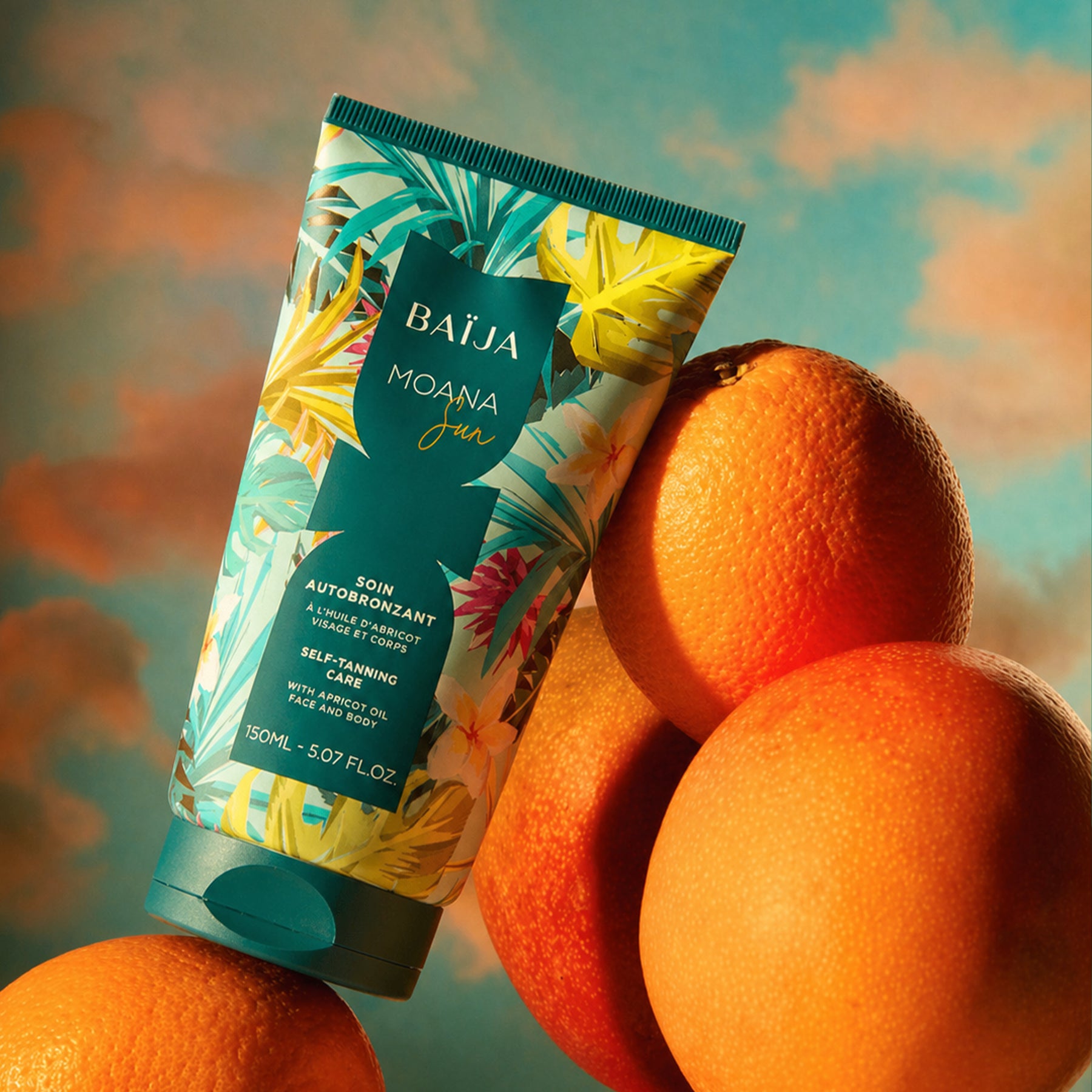 Tube autobronzant Baïja enrichi en huile d’abricot, posé sur des oranges dans une lumière chaude, évoquant un hâle naturel lumineux