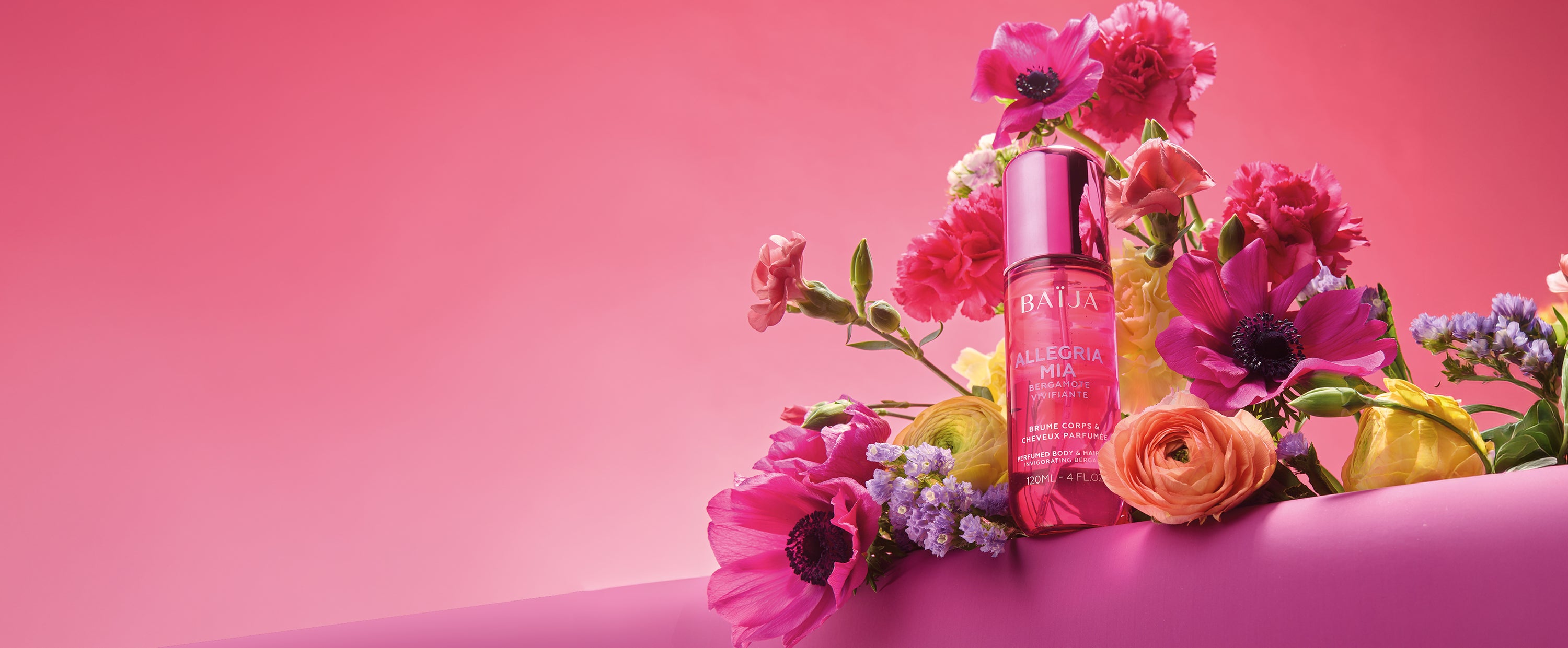 Brume corps et cheveux Alegria Mia Baïja, parfum bergamote vivifiante, mise en scène dans un bouquet floral vibrant aux tons roses et corail.