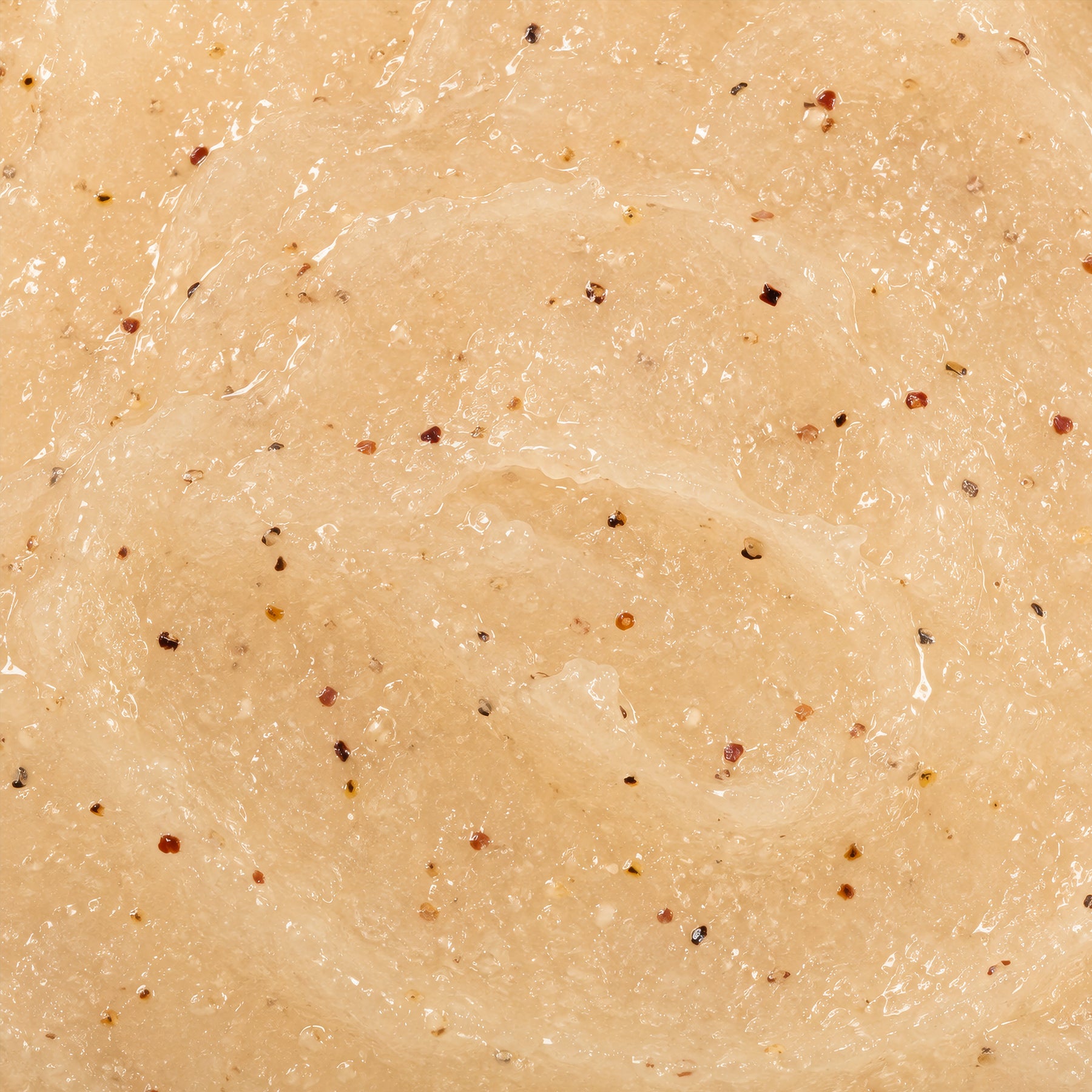 Gros plan sur la texture onctueuse du gommage corps Baïja Moana, révélant ses grains exfoliants et sa formule crémeuse.