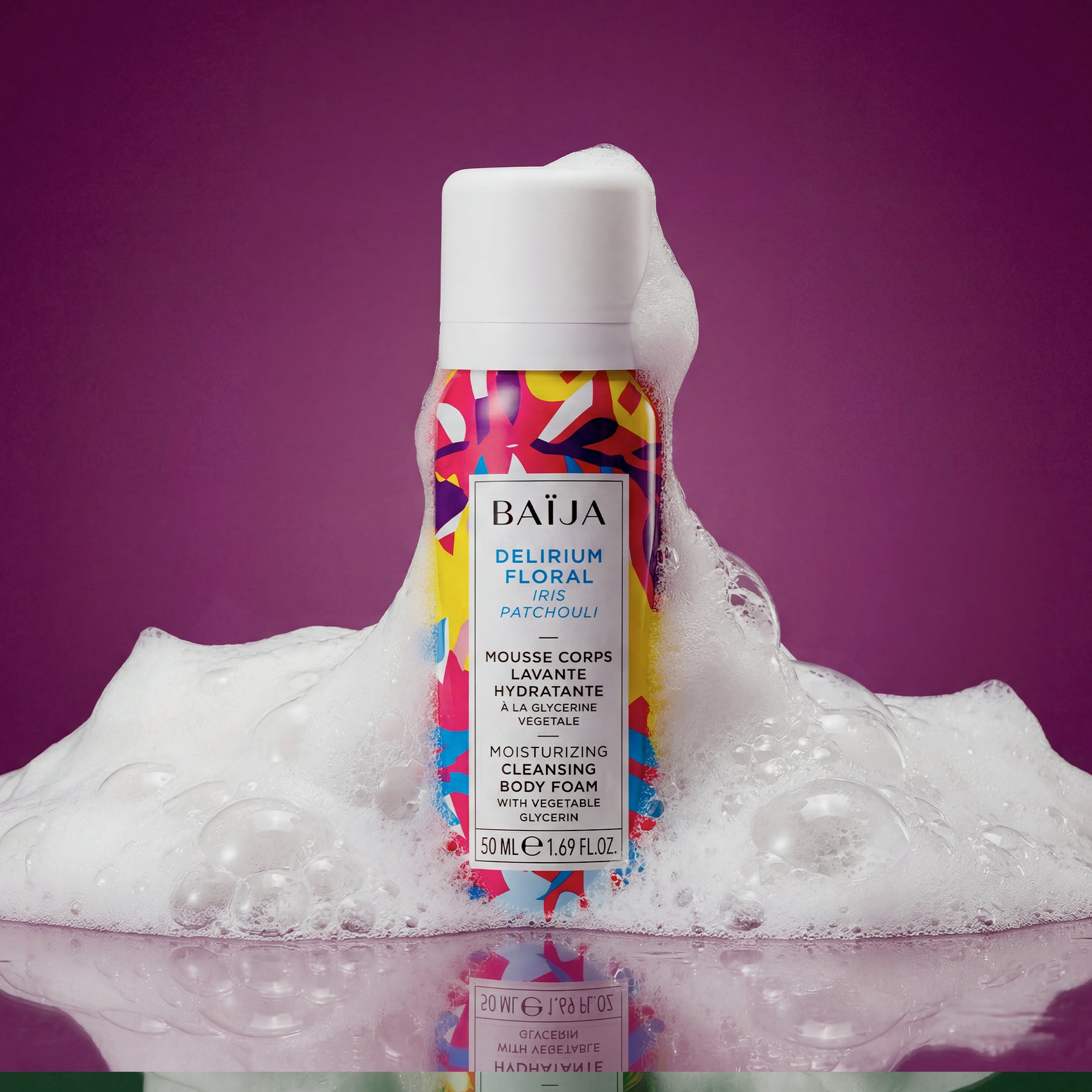 Mousse corps lavante hydratante Baïja Delirium Floral à l’iris et au patchouli, entourée d’une mousse généreuse sur fond violet, évoquant un rituel de douche sensoriel.