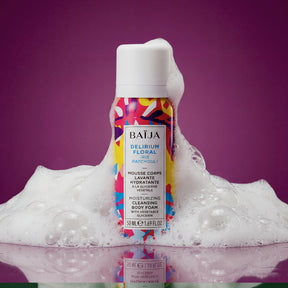 Mousse corps lavante hydratante Baïja Delirium Floral à l’iris et au patchouli, entourée d’une mousse généreuse sur fond violet, évoquant un rituel de douche sensoriel.