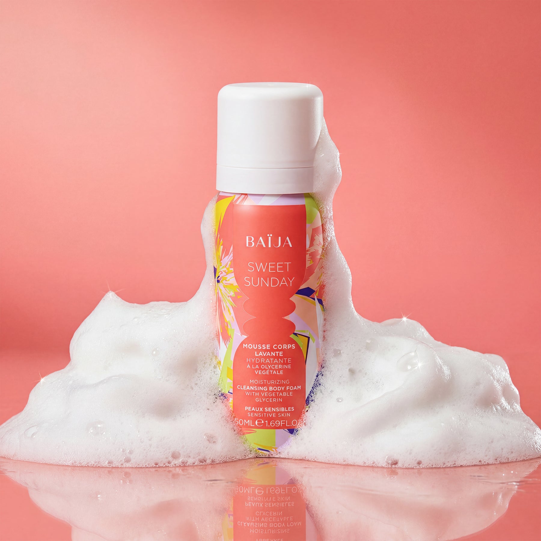 Mousse corps lavante hydratante Baïja Sweet Sunday à la glycérine végétale pour peaux sensibles, entourée d’une mousse onctueuse sur fond rose, évoquant un rituel de douche doux et réconfortant.