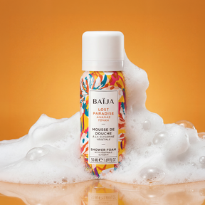 Mousse de douche Baïja Lost Paradise à l’ananas et fève tonka, enveloppée d’une mousse onctueuse sur fond orange, évoquant un rituel de douche exotique et gourmand.