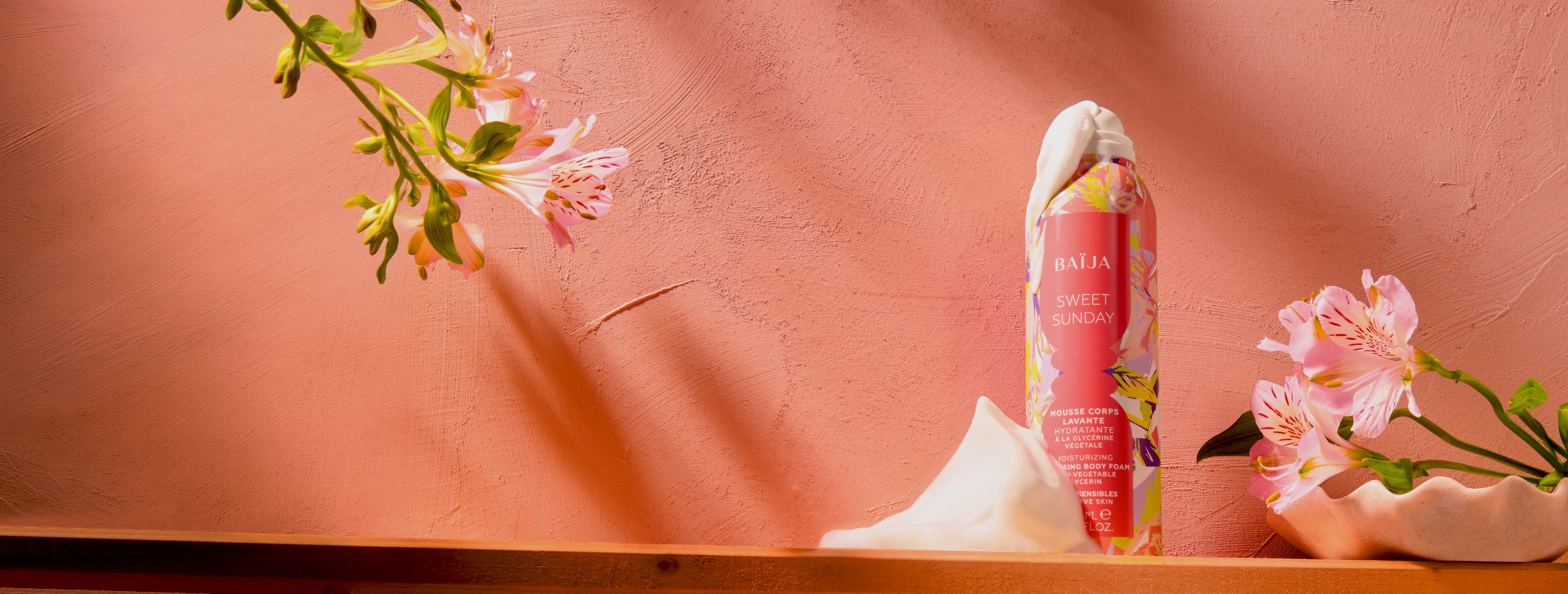 Mousse corps lavante hydratante Sweet Sunday mise en scène avec fleurs délicates et texture aérienne dans une ambiance douce et lumineuse