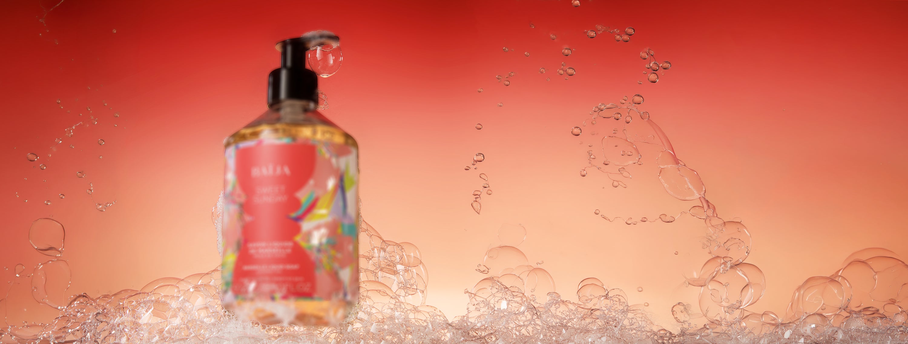 Mise en scène aérienne du savon liquide de Marseille Sweet Sunday avec mousse délicate et ambiance solaire aux tons corail