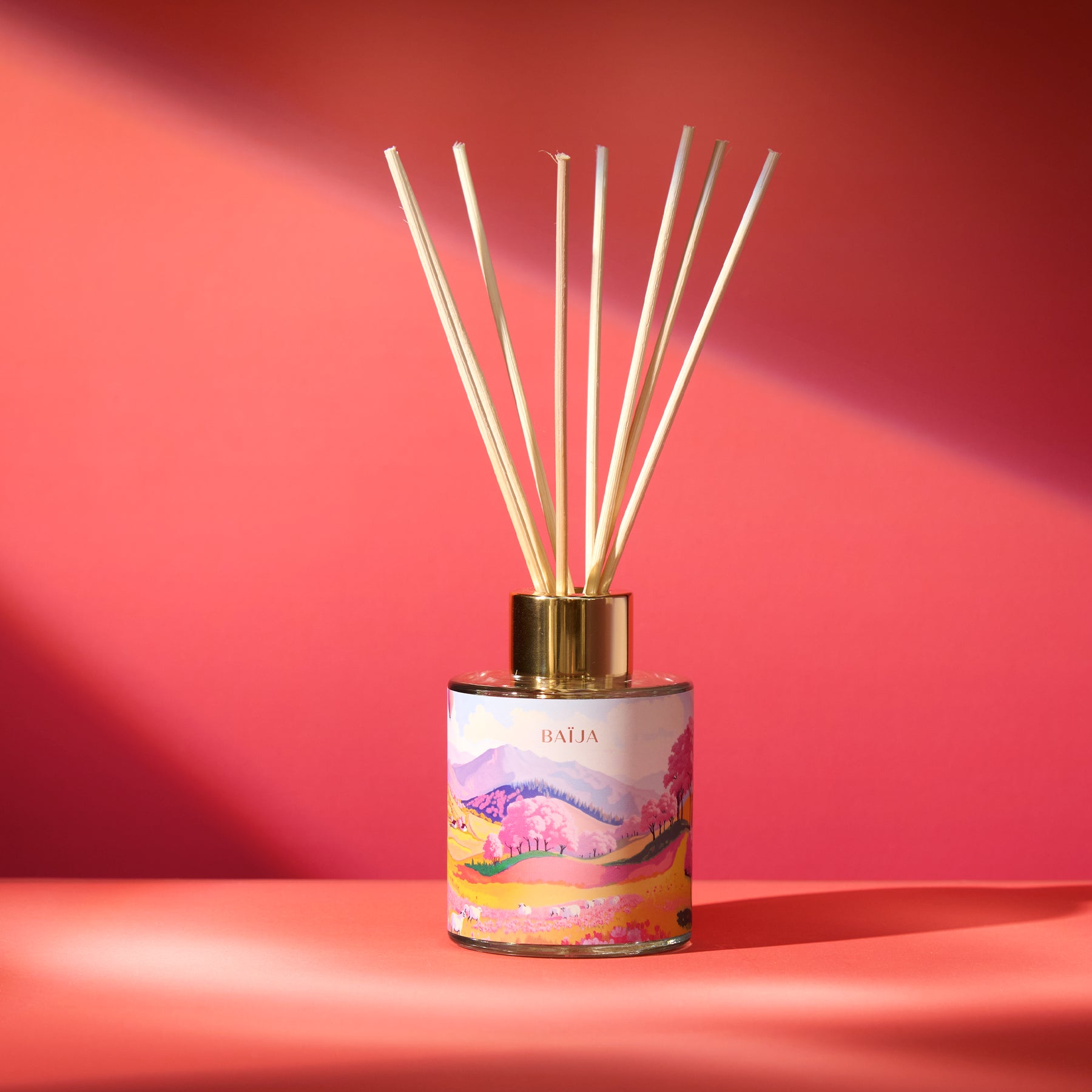 Diffuseur de parfum d’intérieur Sweet Sunday Baïja avec bâtonnets en rotin et décor illustré aux paysages printaniers.