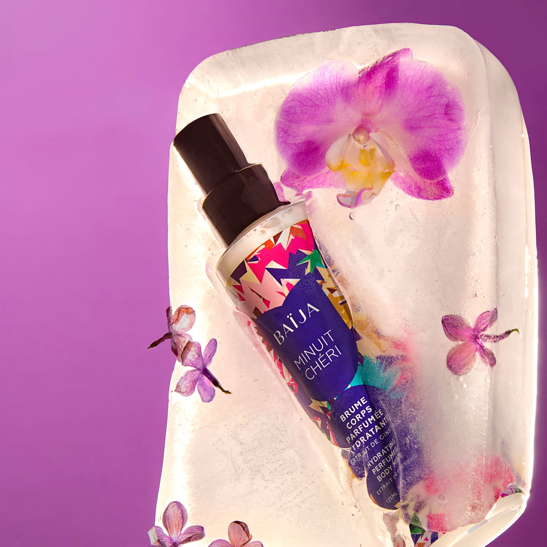 Brume corps parfumée hydratante Baïja Minuit Chéri posée sur un bloc de glace, entourée d’orchidées violettes.
