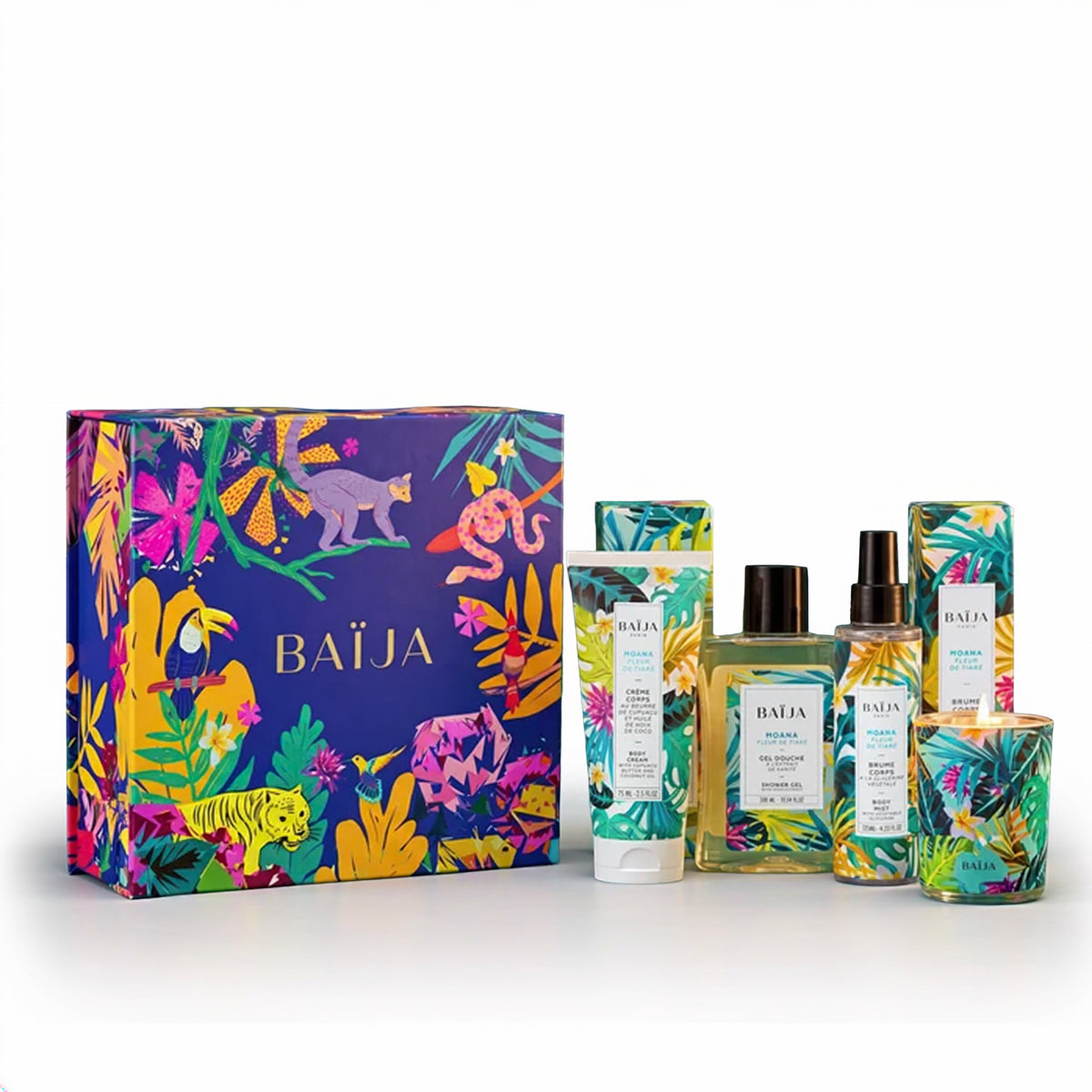 Packshot du coffret à composer Moana Fleur de Tiaré de Baïja, présentant cinq produits : une crème corps, un gel douche, une brume corps, une brume parfumée et une bougie. Les produits aux packagings tropicaux verts, jaunes et turquoise sont disposés devant un coffret cadeau bleu nuit illustré d'animaux exotiques et de fleurs colorées, sur fond blanc.
