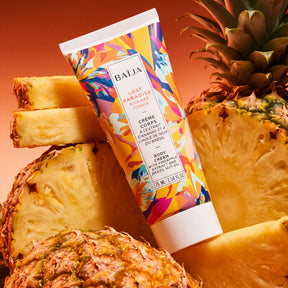 Crème corps Baïja Lost Paradise à l’extrait d’ananas et huile de noix du Brésil, mise en scène au milieu d’ananas frais.