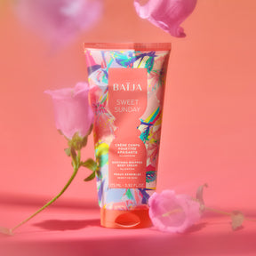 Tube de crème corps Sweet Sunday Baïja mis en scène dans une ambiance florale douce aux teintes rosées