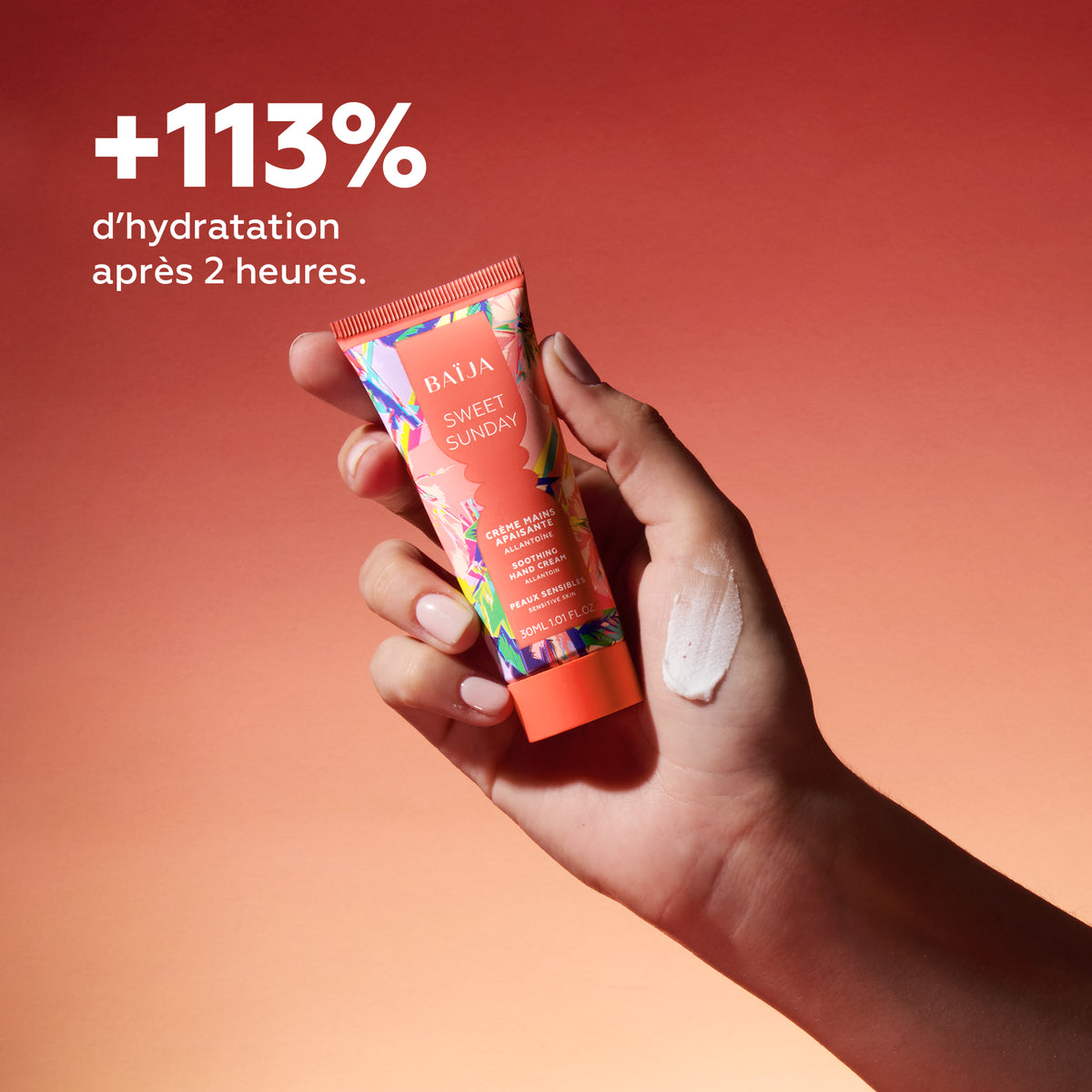 Main tenant la crème mains apaisante Sweet Sunday avec texture visible et promesse d’hydratation durable