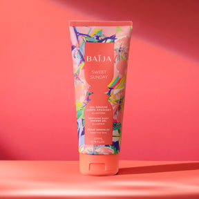 Tube de gel douche Sweet Sunday Baïja mis en scène sur fond rose solaire, évoquant douceur et réconfort