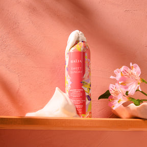 Mousse corps lavante Sweet Sunday à la glycérine végétale, mise en scène avec mousse généreuse et fleurs délicates