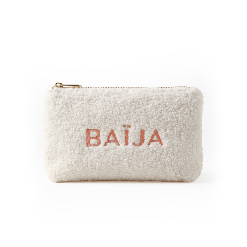 Trousse de rangement Baïja en tissu bouclette écru, fermeture zippée dorée et logo brodé ton corail