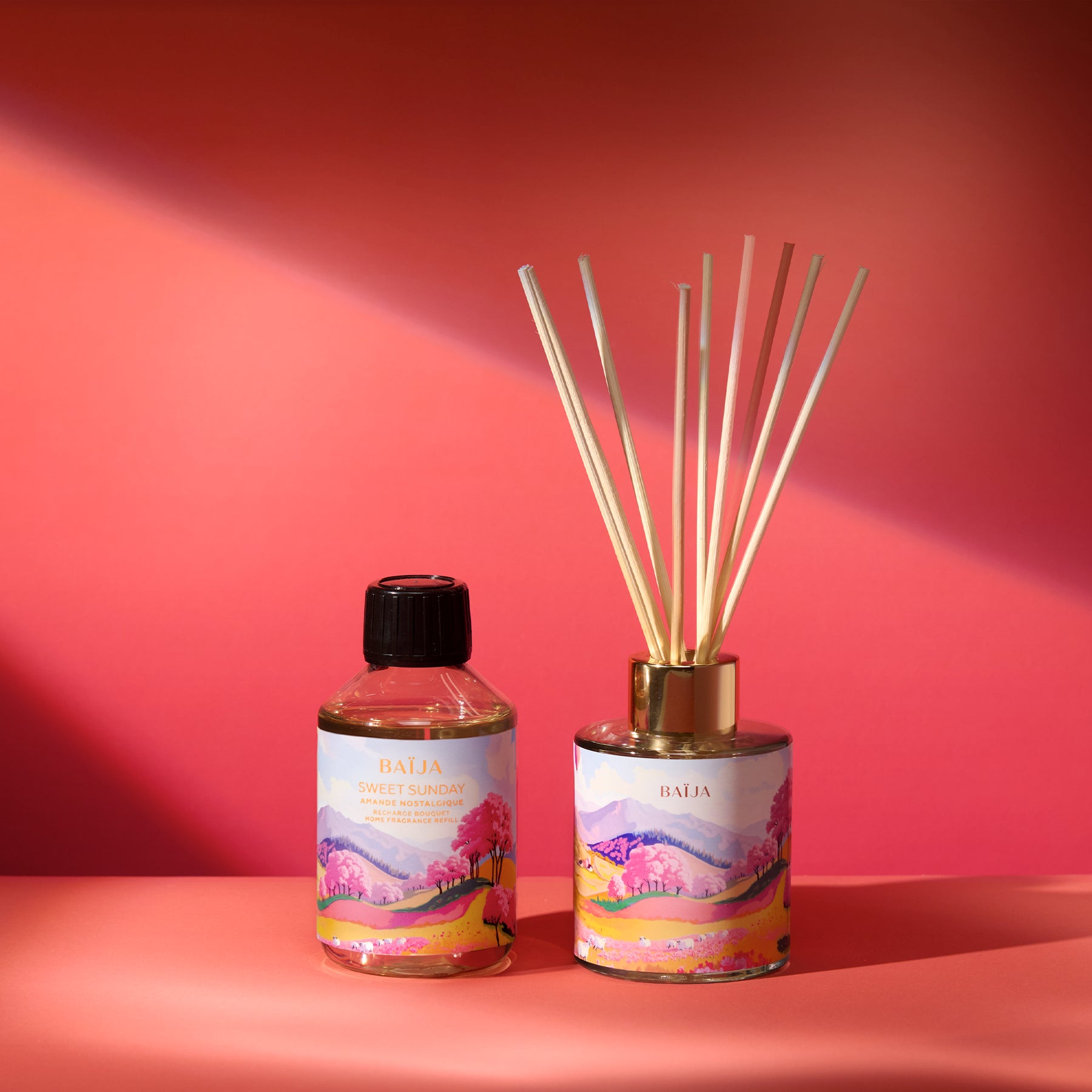 Recharge de parfum d’intérieur et diffuseur Sweet Sunday Baïja présentés sur fond rose aux accents printaniers.