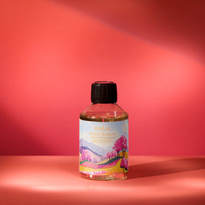 Recharge pour bouquet parfumé Sweet Sunday Baïja, flacon décoré d’un paysage printanier aux tons pastel
