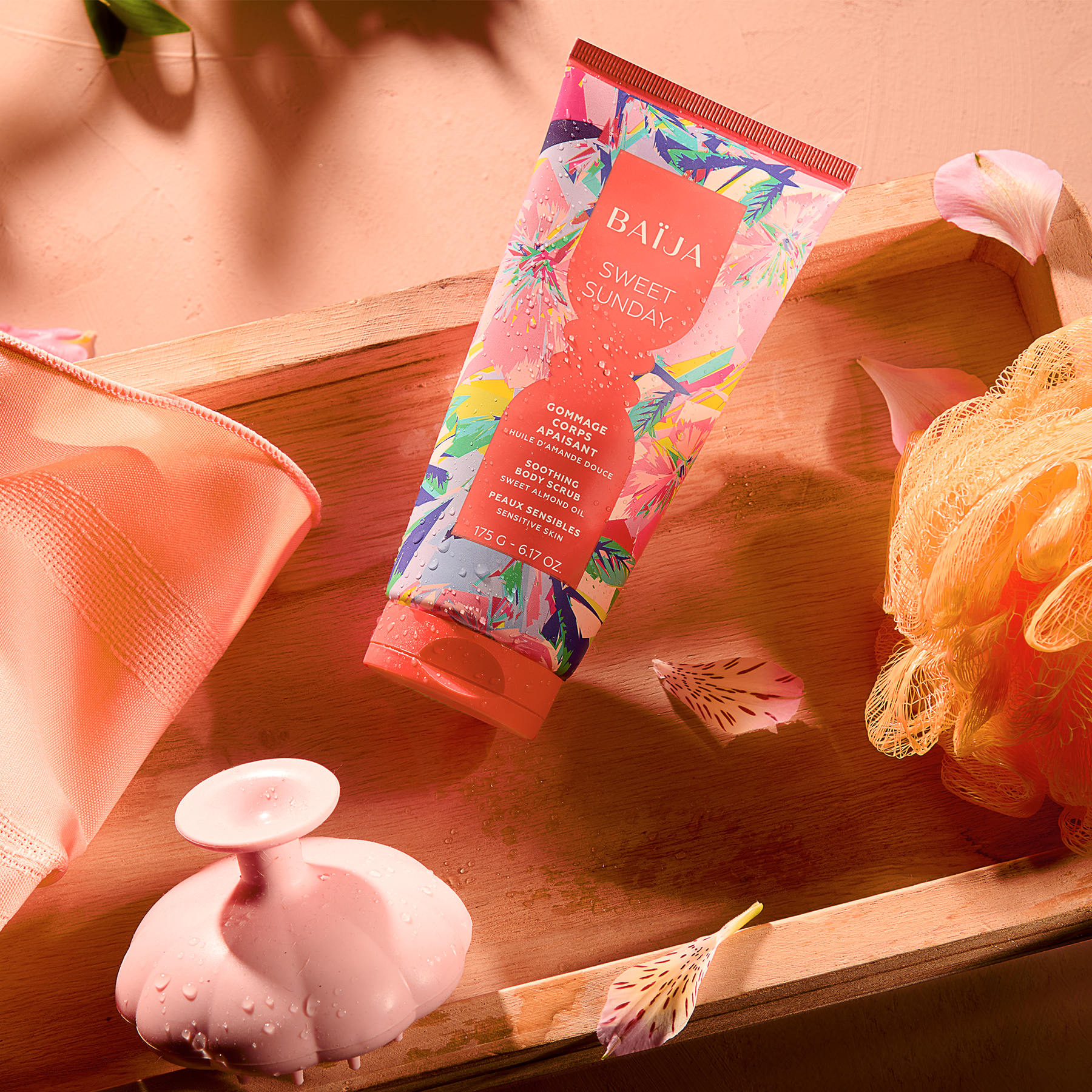 Rituel de soin exfoliant Sweet Sunday présenté sur un plateau en bois avec brosse de massage et accessoires de bain