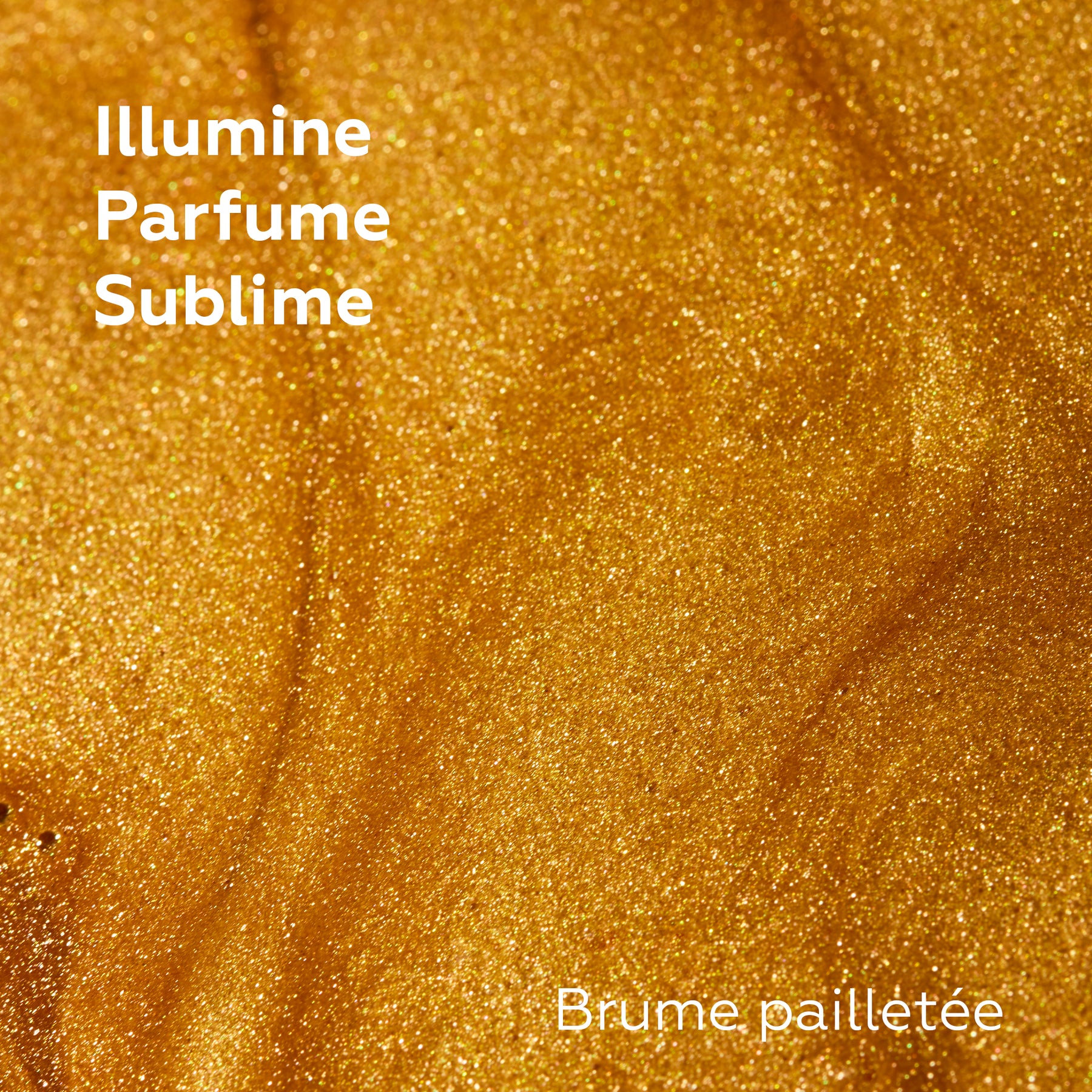 Macro de la texture dorée d’une brume pailletée Baïja, aux fines nacres lumineuses offrant un voile scintillant et parfumé.