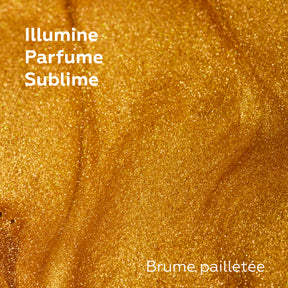 Macro de la texture dorée d’une brume pailletée Baïja, aux fines nacres lumineuses offrant un voile scintillant et parfumé.