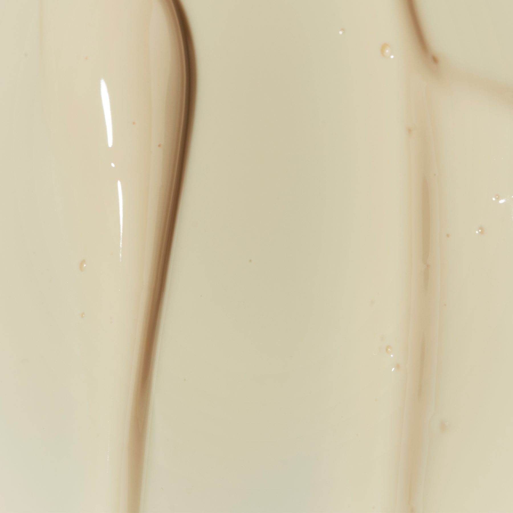 Texture de fluide solaire SPF50+ Baïja Moana Sun, lait soyeux beige aux reflets lumineux, fini doux et invisible sur la peau